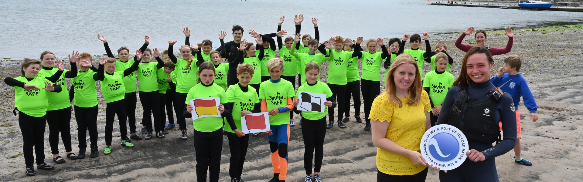 Sara Richards From The Port Of Milford Haven And Miyah Periam, Senior Instructor At Windswept, With Year 6 Pupils From Cleddau Reach School At Dale Beach