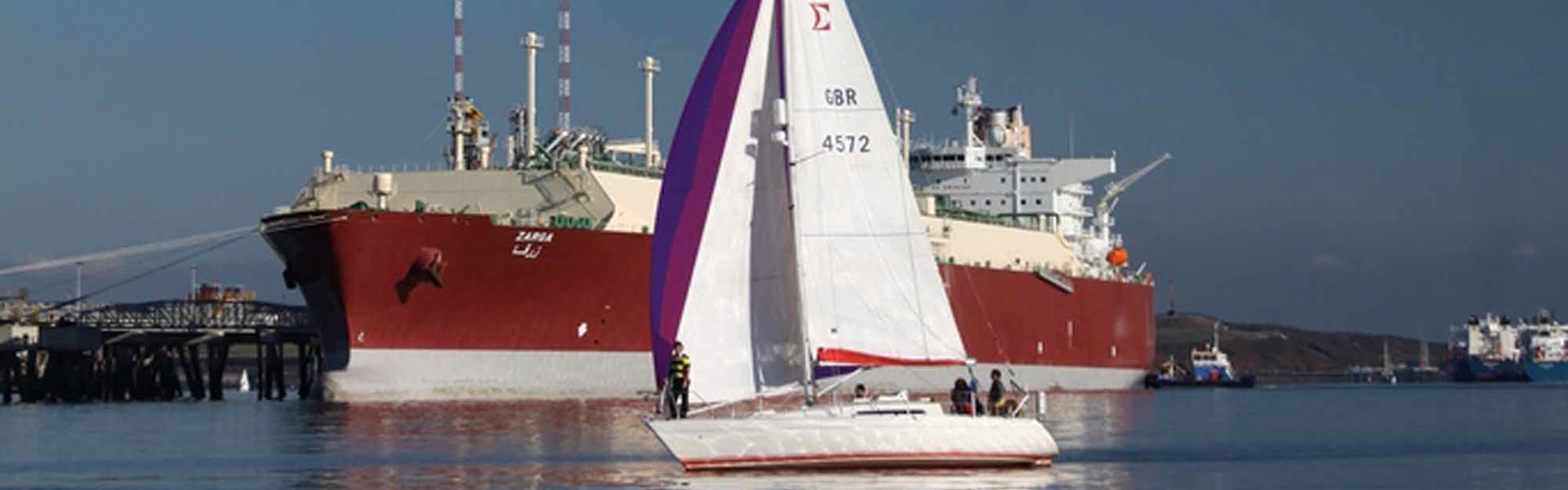 Yacht sailing past a Q Max LNG carrier